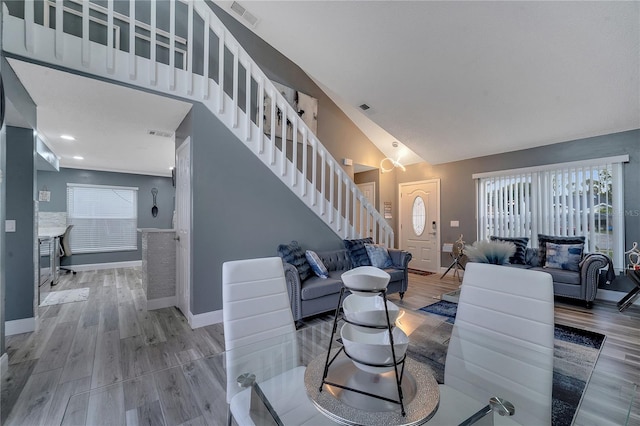 living room with hardwood / wood-style flooring and high vaulted ceiling