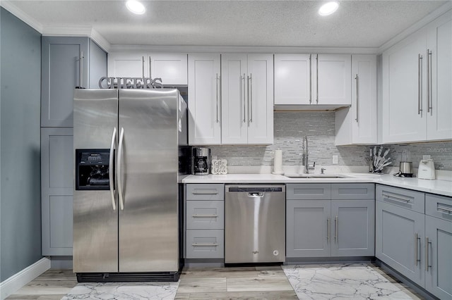 kitchen with stainless steel appliances, sink, gray cabinetry, and decorative backsplash