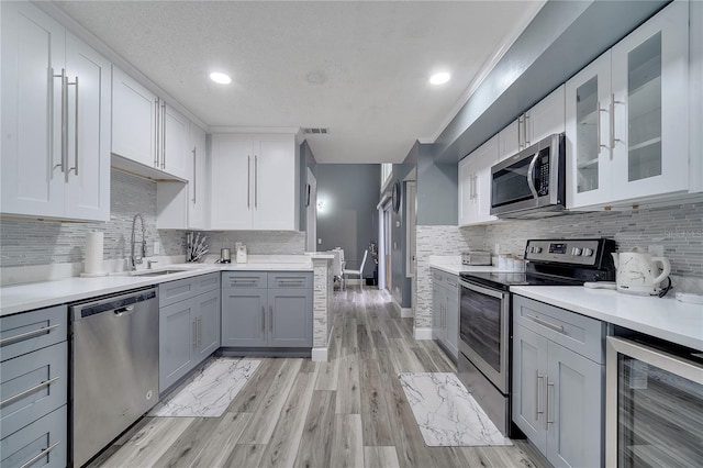 kitchen featuring wine cooler, sink, gray cabinets, and stainless steel appliances