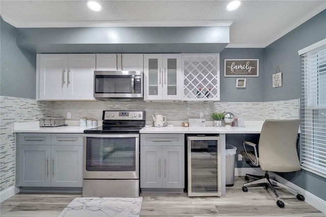 kitchen with wine cooler, stainless steel appliances, crown molding, and gray cabinetry