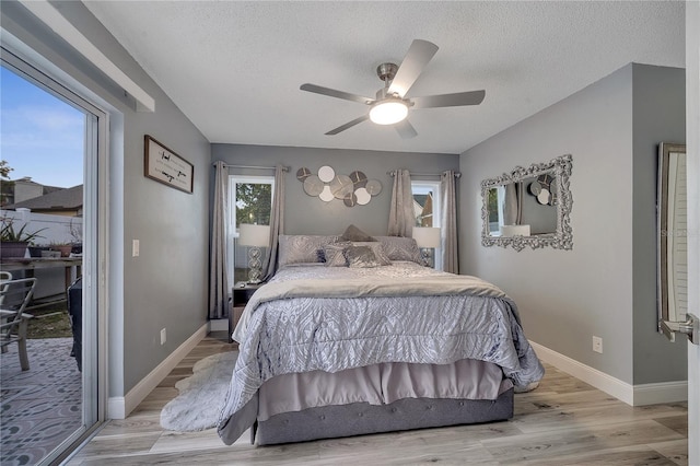 bedroom featuring ceiling fan, light hardwood / wood-style floors, and a textured ceiling