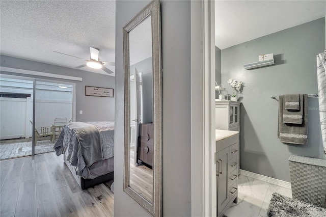 bathroom featuring vanity, ceiling fan, and a textured ceiling