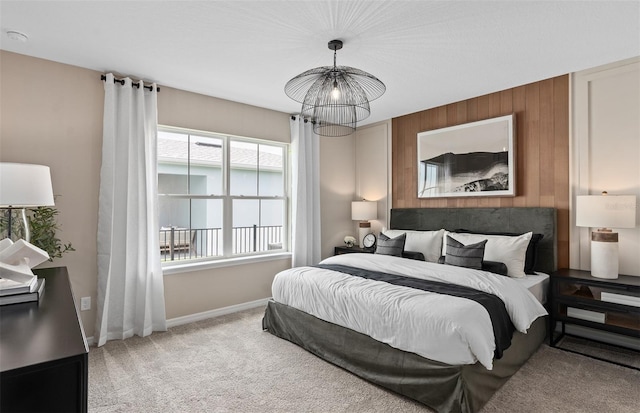 carpeted bedroom featuring wooden walls and a chandelier