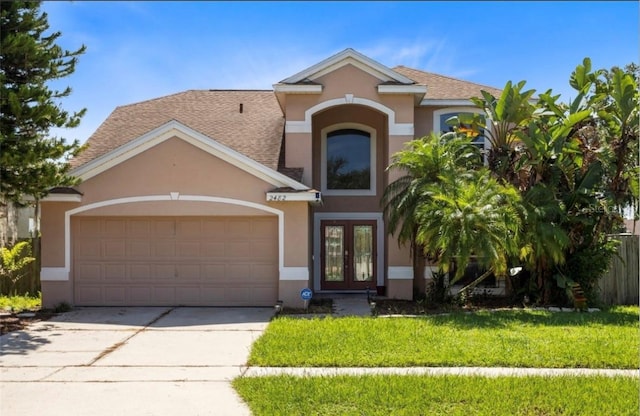 view of front of property with a garage, a front yard, and french doors