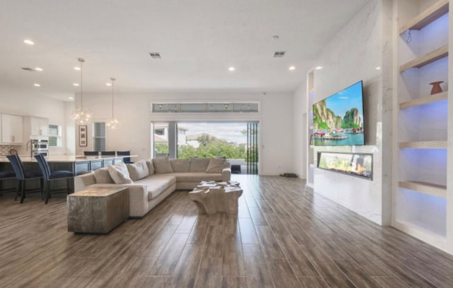 living room with dark hardwood / wood-style floors and a chandelier