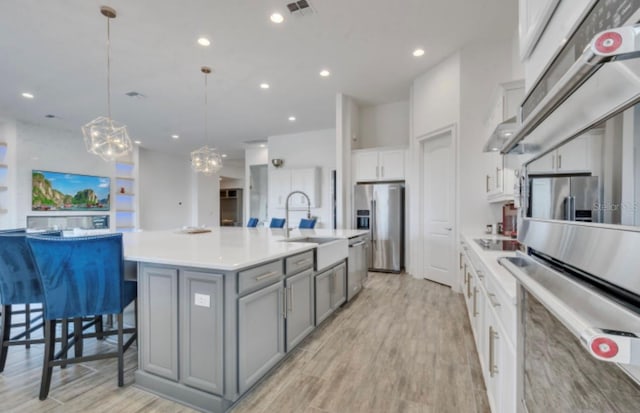 kitchen featuring sink, a breakfast bar area, hanging light fixtures, a large island, and stainless steel appliances