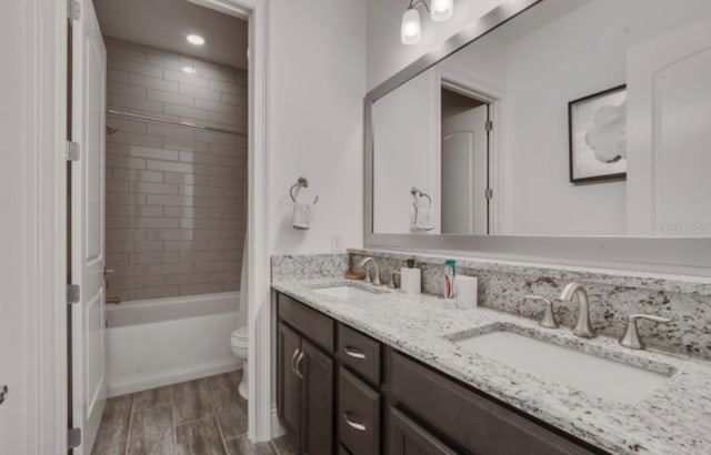 full bathroom with vanity, tiled shower / bath, and toilet