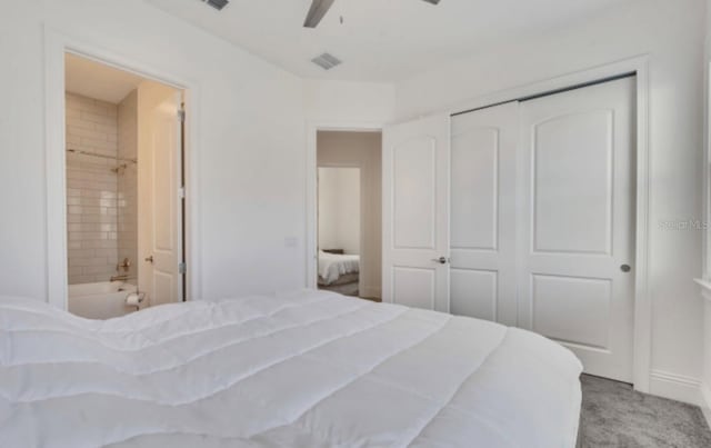 bedroom featuring light carpet, ensuite bath, a closet, and ceiling fan