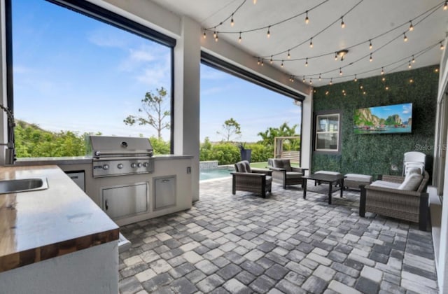 view of patio with a grill, an outdoor hangout area, exterior kitchen, and sink