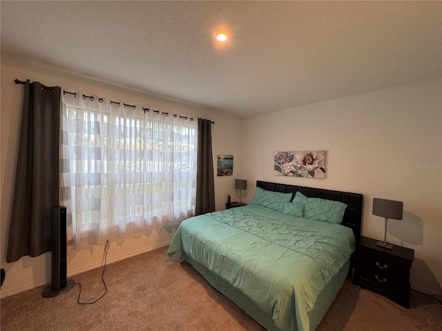 bedroom featuring light colored carpet and a textured ceiling