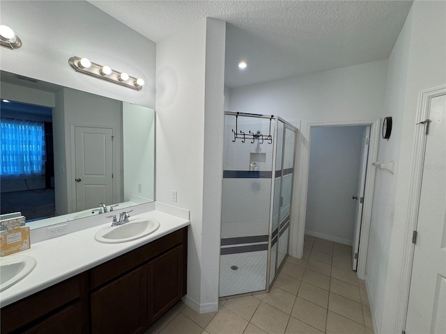 bathroom with vanity, tile patterned flooring, a textured ceiling, and walk in shower