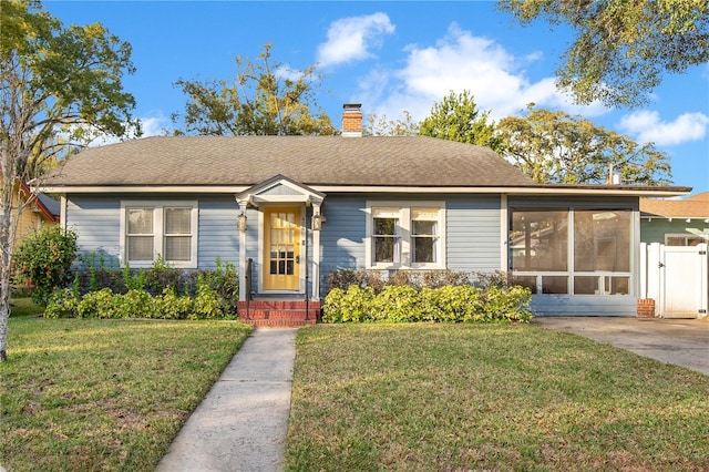 view of front facade featuring a front lawn and a sunroom