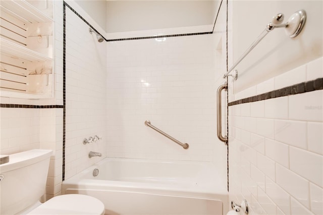 bathroom with tiled shower / bath combo and toilet