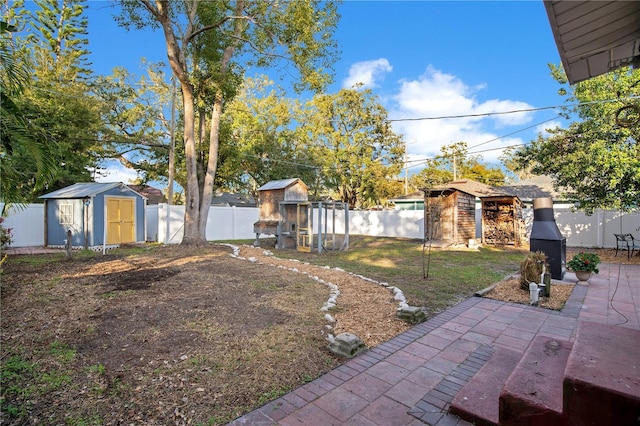 view of yard featuring a patio area, a fenced backyard, a shed, and an outdoor structure