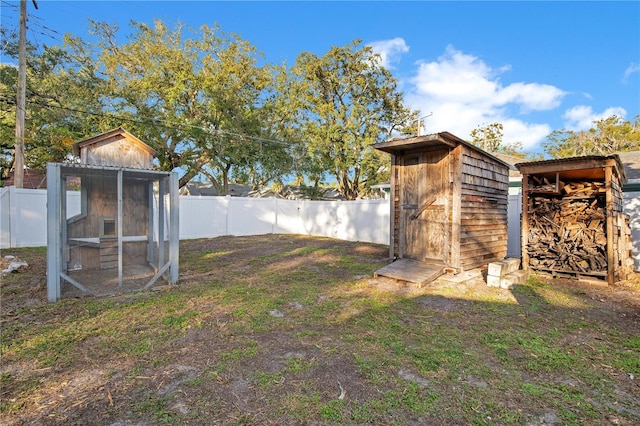 view of yard featuring an outbuilding, a fenced backyard, a shed, and exterior structure