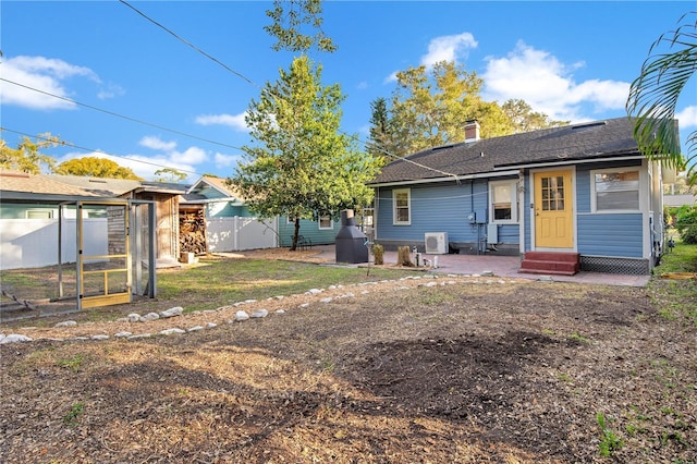 rear view of property with entry steps, a shingled roof, fence, a chimney, and a patio area