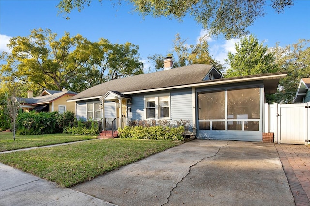 ranch-style house featuring a sunroom and a front yard