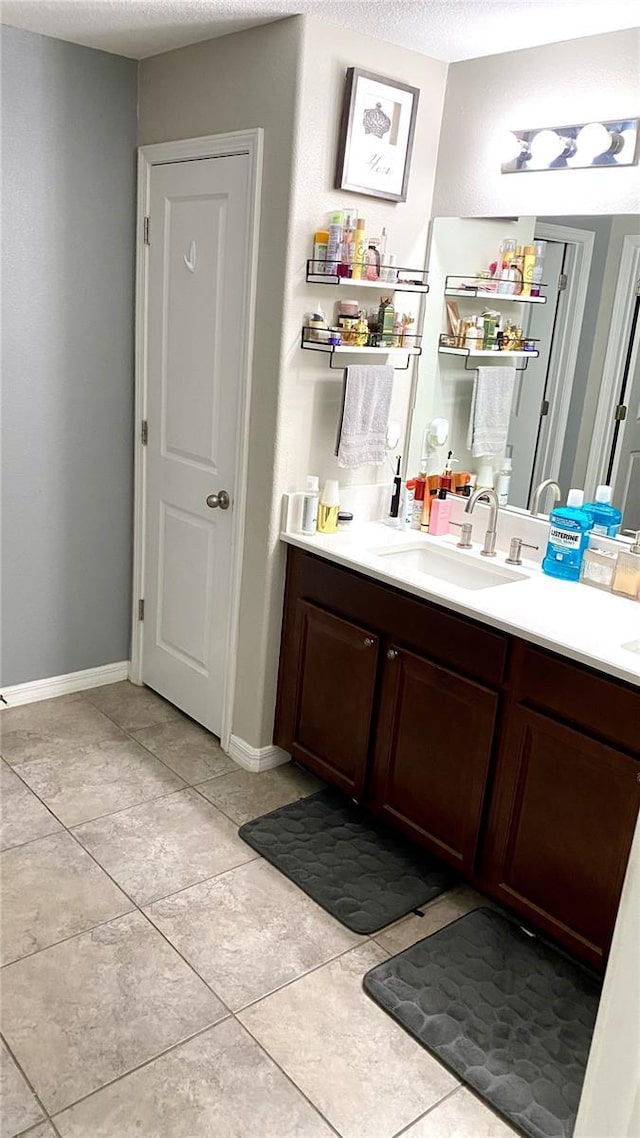 bathroom with vanity, tile patterned flooring, and a textured ceiling