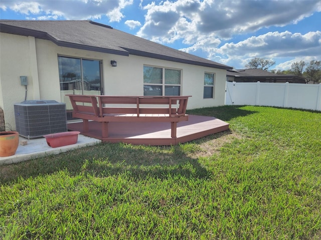 back of property featuring central AC, a wooden deck, and a lawn