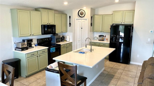 kitchen featuring light tile patterned flooring, sink, backsplash, black appliances, and a center island with sink