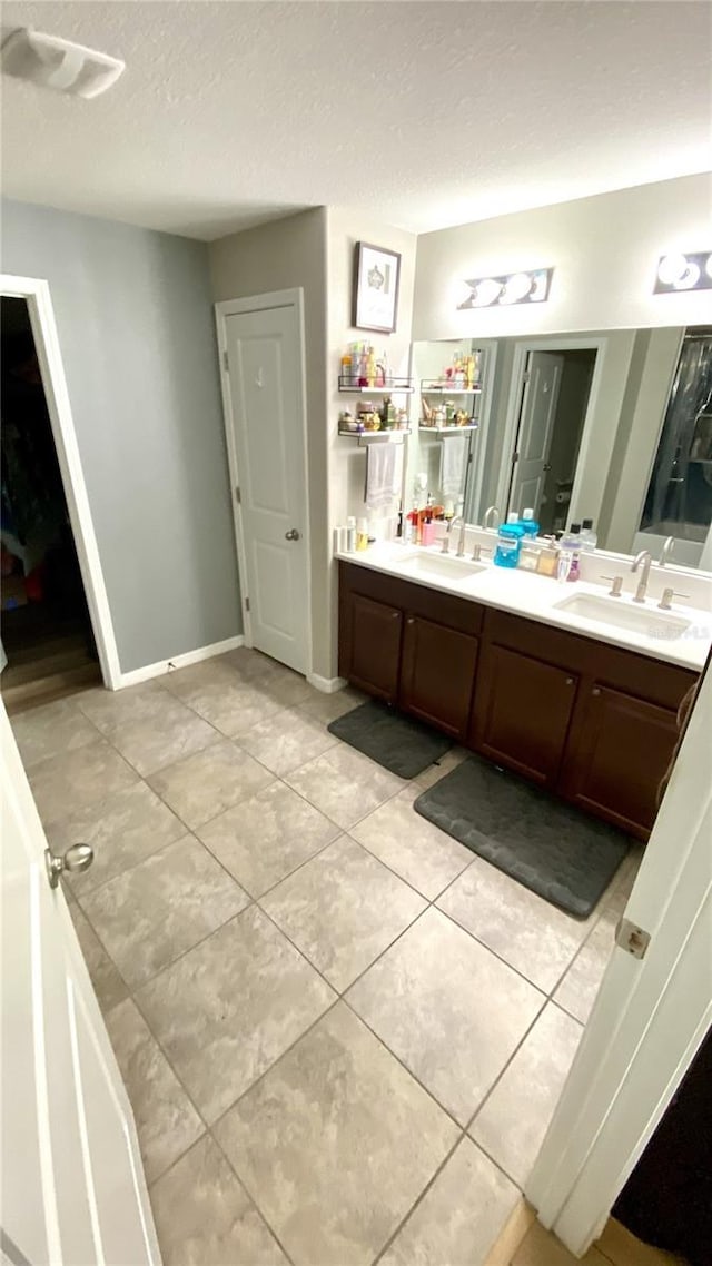 bathroom featuring vanity, tile patterned floors, and a textured ceiling