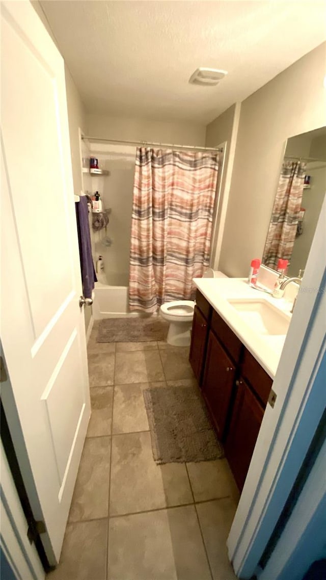 full bathroom featuring vanity, a textured ceiling, toilet, and shower / tub combo with curtain