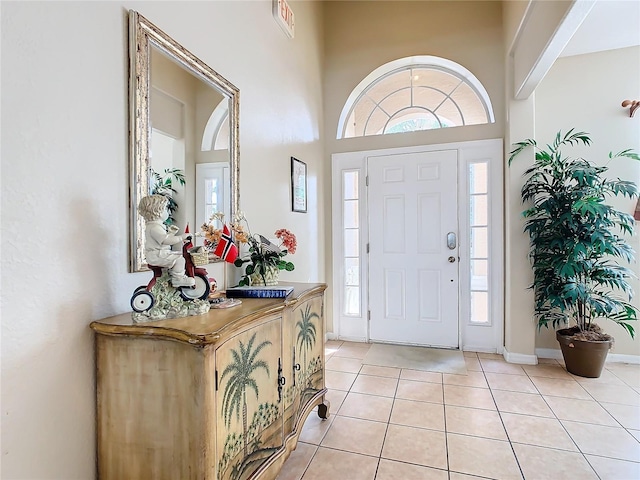 foyer featuring a towering ceiling and light tile patterned floors