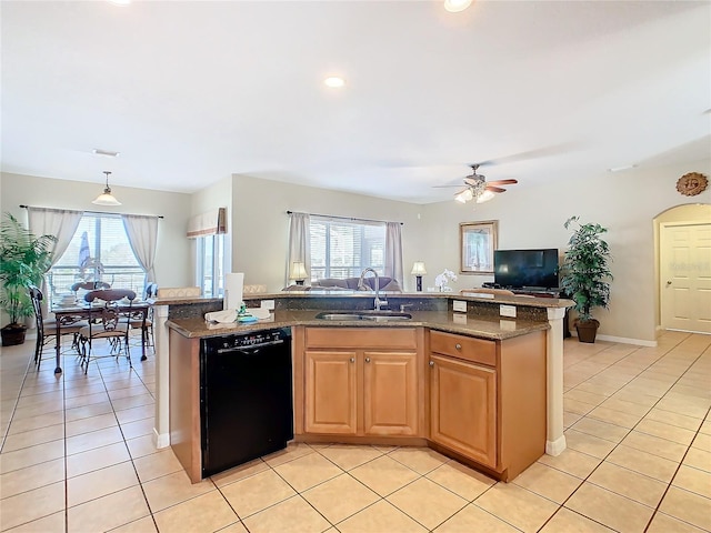 kitchen with sink, a center island with sink, light tile patterned floors, dark stone countertops, and dishwasher