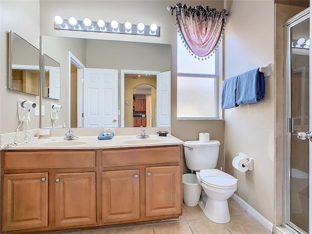 bathroom with toilet, vanity, tile patterned floors, and walk in shower