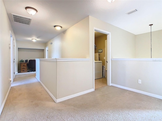 hall featuring washer / clothes dryer and light colored carpet