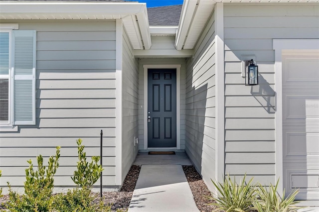 property entrance featuring a shingled roof