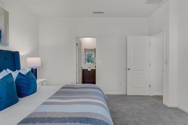 bedroom with ensuite bath and carpet