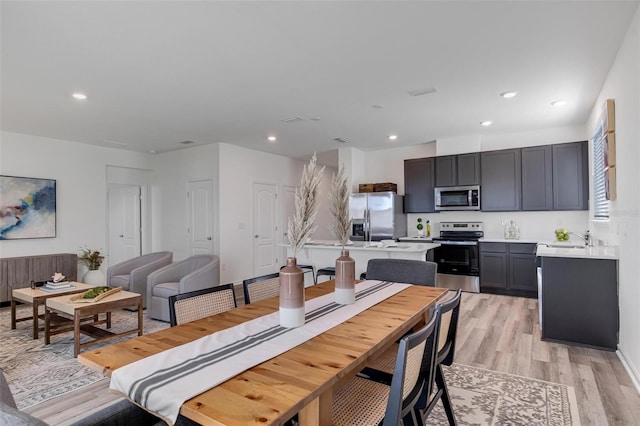 dining area featuring sink and light hardwood / wood-style floors