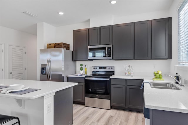 kitchen featuring sink, stainless steel appliances, light hardwood / wood-style floors, and a healthy amount of sunlight