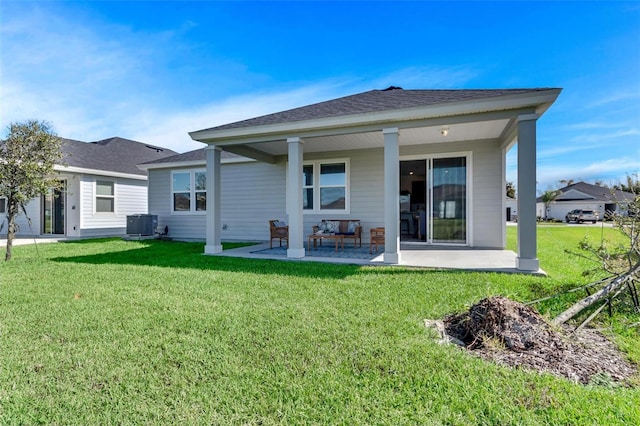 rear view of house featuring a lawn, central AC unit, and a patio area