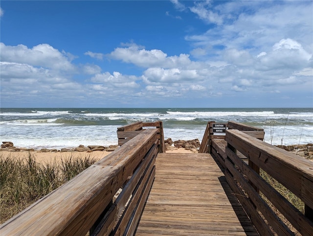 view of home's community featuring a water view and a beach view