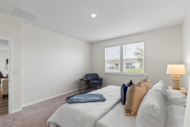 carpeted bedroom featuring visible vents and baseboards