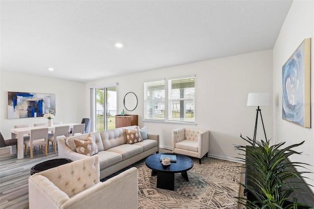 living area with light wood-type flooring, baseboards, and recessed lighting