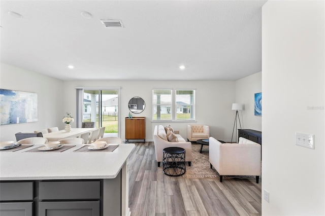 living area with recessed lighting, visible vents, and light wood-style floors