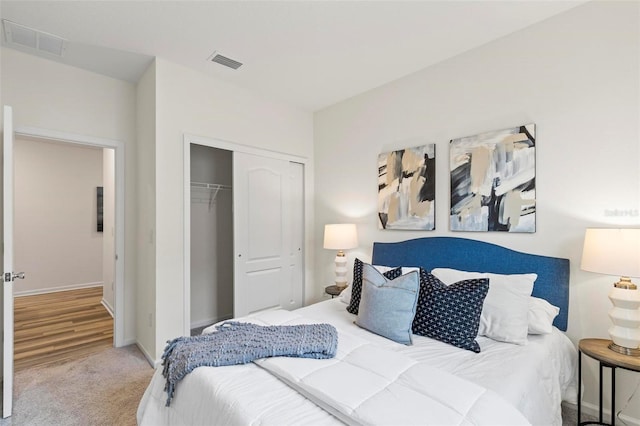 carpeted bedroom featuring a closet, visible vents, and baseboards