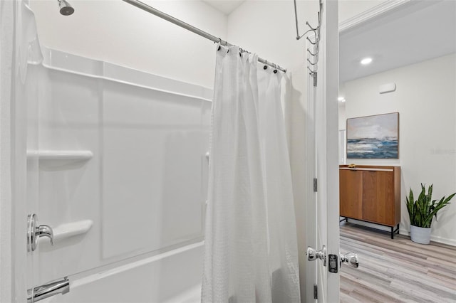 full bath featuring baseboards, shower / bath combo with shower curtain, and wood finished floors