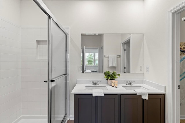 bathroom with double vanity, a sink, and a shower stall