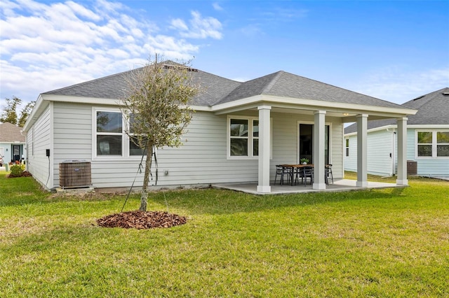 back of property featuring a patio area, roof with shingles, and a yard