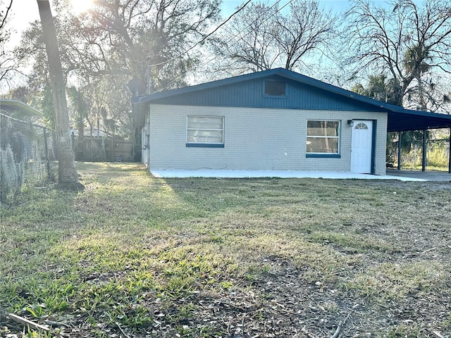 exterior space featuring a carport and a front lawn