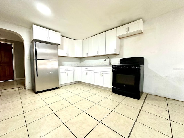 kitchen featuring white cabinetry, sink, black range with gas stovetop, and stainless steel refrigerator