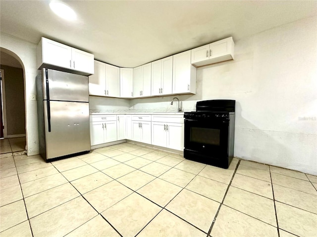 kitchen with stainless steel refrigerator, sink, gas stove, and white cabinets