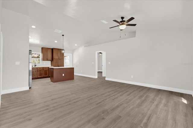 unfurnished living room with ceiling fan, lofted ceiling, and light hardwood / wood-style floors