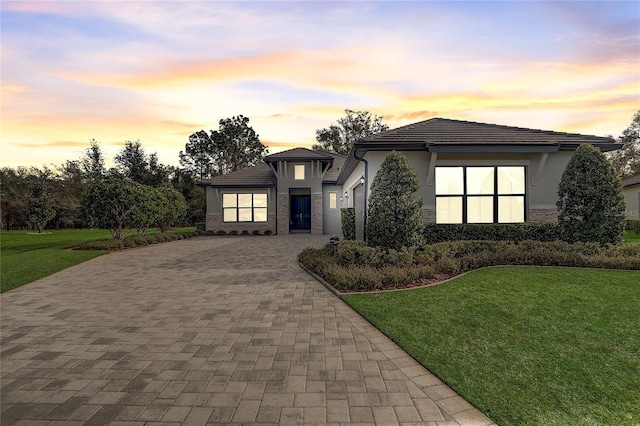 view of front of house with a garage and a lawn