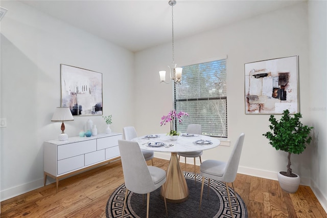 dining space featuring an inviting chandelier and light hardwood / wood-style flooring