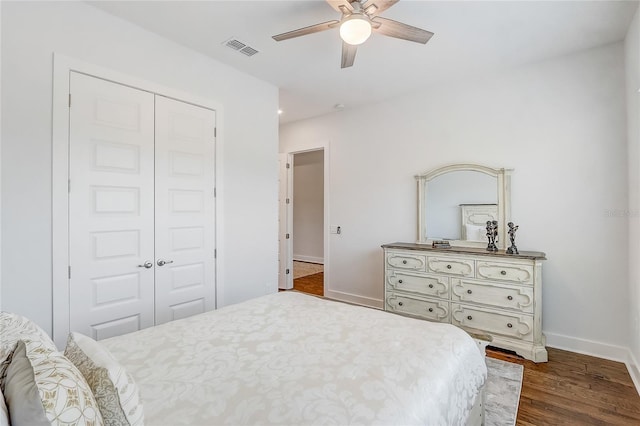 bedroom featuring dark hardwood / wood-style floors, ceiling fan, and a closet